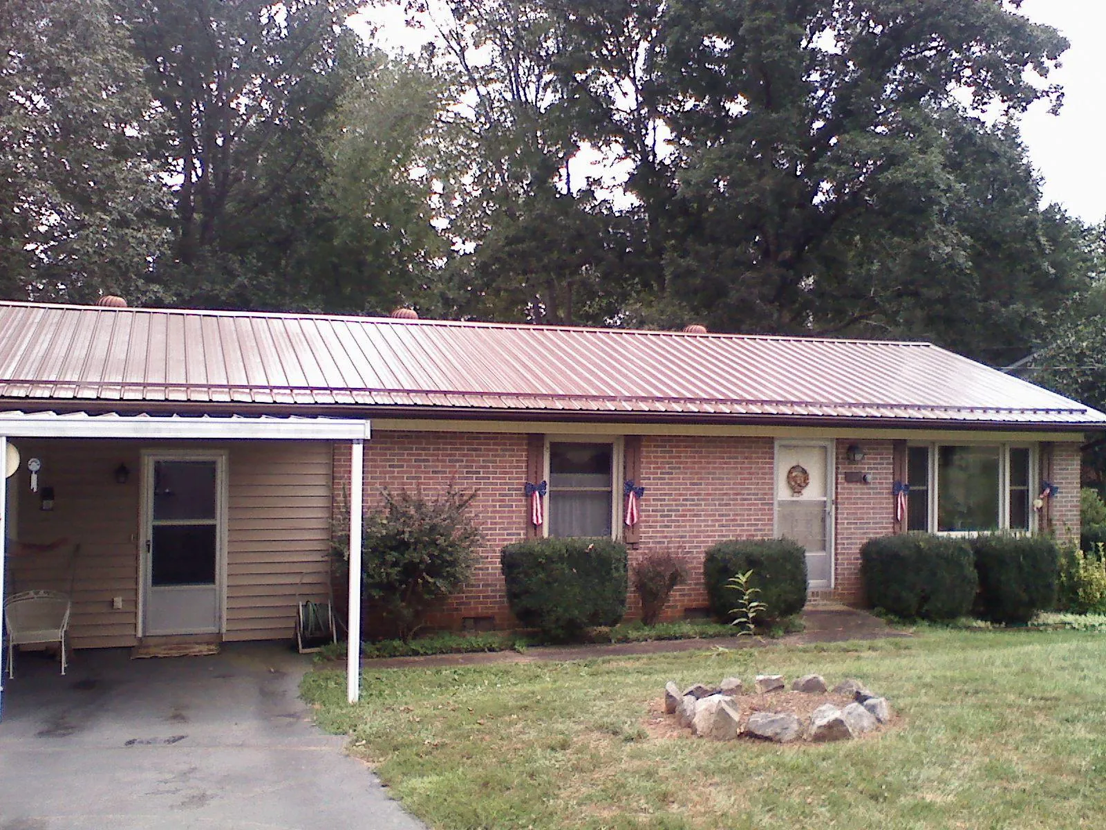 Bronze metal roof and carport on a brick ranch home — Roof Repair work by our crew in Rushville